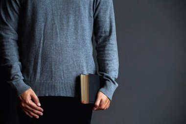 Genç bir adam elinde siyah bir İncil tutuyor. Hıristiyanlar ve İncil çalışma 
