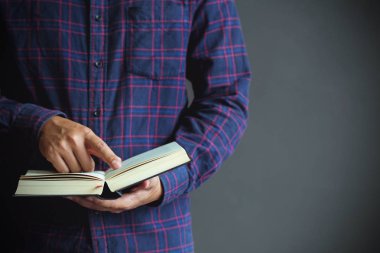 Genç adam bir kitap açıp okuyor, uzayı kopyala, kapat.