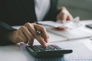 Hesap makinesi kullanarak masa başında çalışan iş adamlarının elleri rakamları hesaplamak ve muhasebe kavramını finanse etmek için.