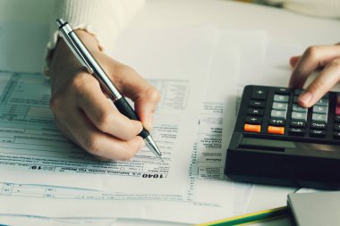 ABD vergi formunu dolduran kadınlar. Vergi formları iş gelirleri ofisi elle doldurma kavramı. Evden çalışma.