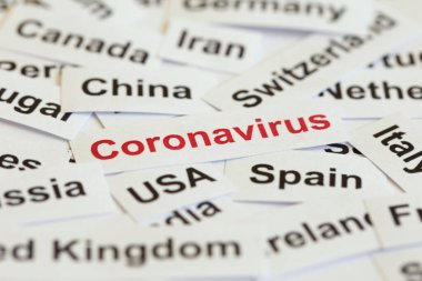 Coronavirus salgını. Kağıt üzerinde Coronavirus kelimesi ile yazılır. Bu kelime farklı ülkelerin isimlerini yazar..