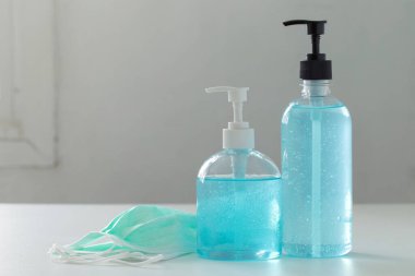 Önleme seti, el hijyeni için el dezenfektanı jeli ve beyaz masada tıbbi cerrahi maskeler, sağlık hizmeti konsepti. Corona virüs koruması..