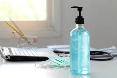 Evden çalışıyorum. Coronavirus önleme tıbbi maskeler ve el dezenfektanı masaya konuldu.