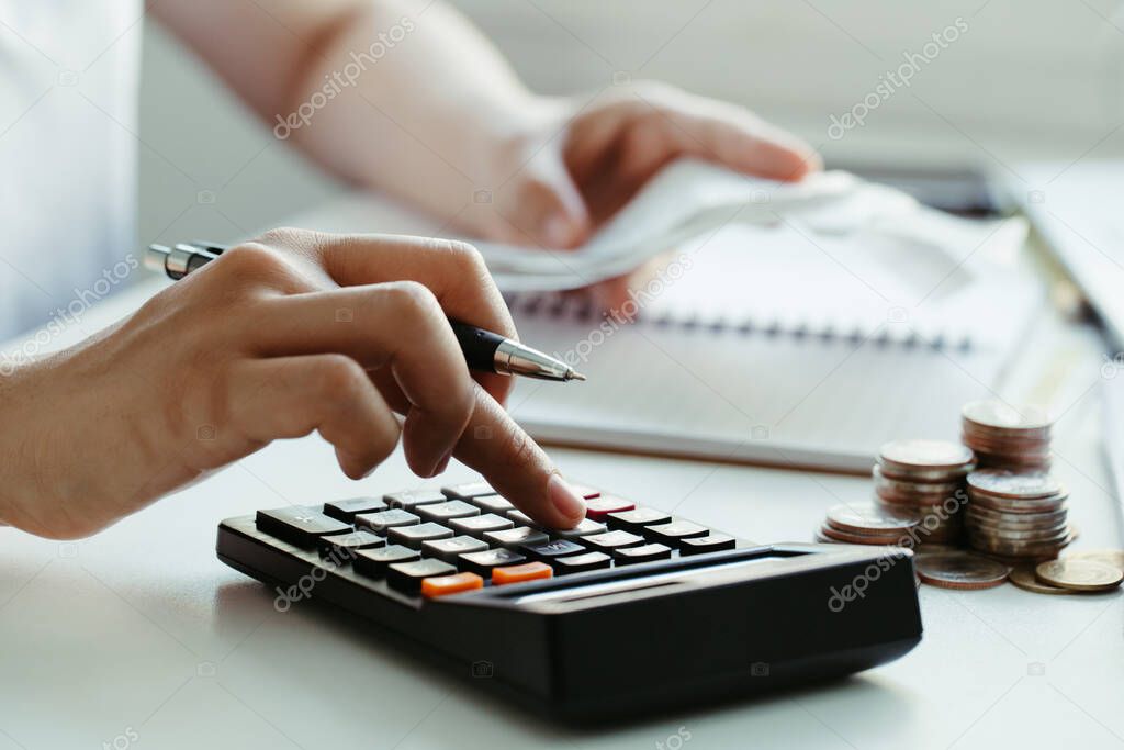 women calculate domestic bills at home. using calculator at modern office and checking balance and costs.women doing paperwork for paying taxes