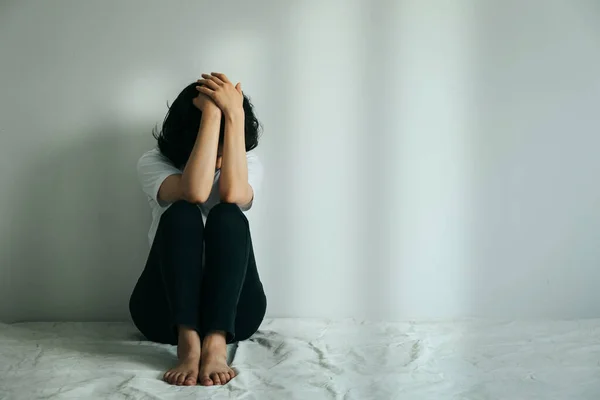 这个抑郁的女人抱着膝盖哭了 悲伤的女人一个人坐在空房间里 — 图库照片