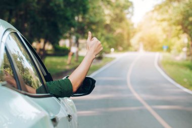Otostop çeken bir adam. Turist otostop çekiyor. Yolda arabada oturuyor.