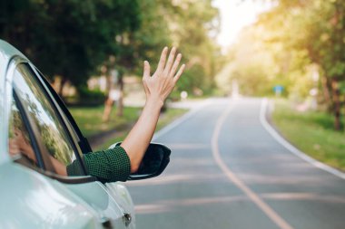 Otostop çeken bir adam. Turist otostop çekiyor. Yolda arabada oturuyor.