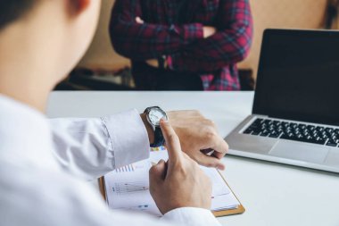 El kol saatine işaret eden iş adamının yakın görüntüsü