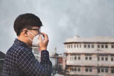 Nefes alamıyorum. Hava kirliliği ve toz parçacıklarına karşı solunum maskesi takan adam güvenlik sınırlarını aşıyor. Sağlık, çevre, ekoloji konsepti. Alerji, baş ağrısı..