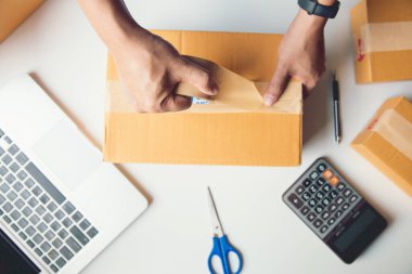 Sevkiyat Çevrimiçi Satış. Erkek işçi teslimat servisi ve paketleme kutusu, işletme sahibi posta göndermeden önce kontrol emri için çalışıyor. Top view