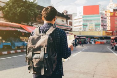 Genç gezgin gezgin yaz aylarında yurtdışına seyahat ederken haritada yön arıyor