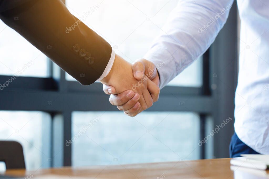 Business people shaking hands, finishing up a meeting.handshake of happy business people after contract agreement to become a partner,collaborative teamwork.