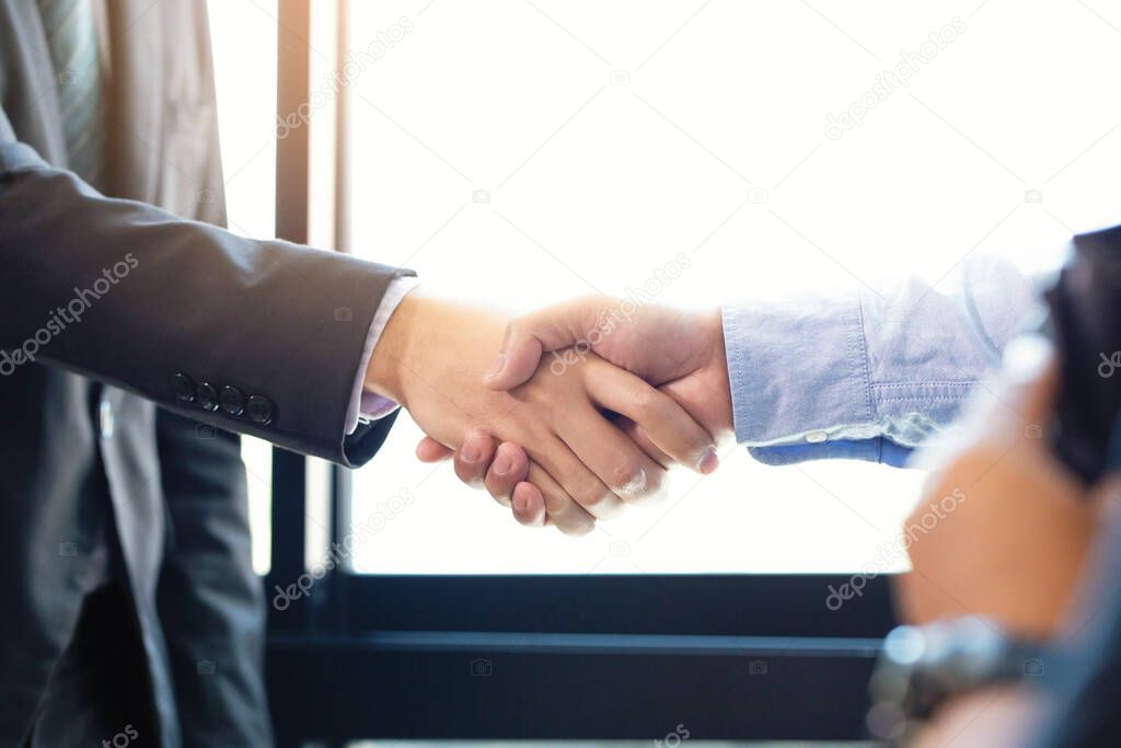 Partnership and Social connection in business join hand together,Finishing up a meeting,handshake of happy business people after contract agreement to become a partner,collaborative teamwork.