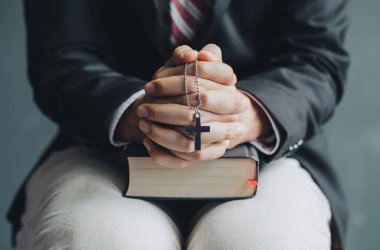 İsa 'yı çarmıha geren ve dua eden iş adamları ve kutsal İncil.