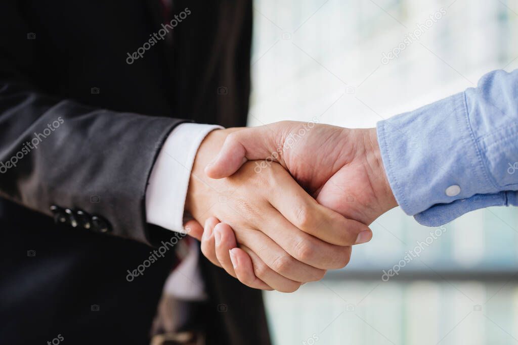 Closeup image of two business shaking hands.Success teamwork, partnership and handshake