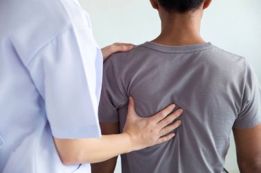 Fizyoterapist adamın sırtında tedavi uyguluyor. Sırt ağrısı, hasta, tedavi, tıp doktoru, masaj terapisti. Ofis sendromu.