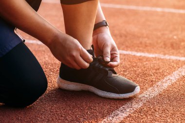Stadyumdaki ayakkabı bağcığında oturan sporcu. Başlangıç Konsepti.