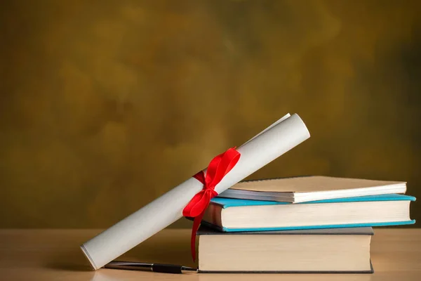 Scroll of certificate ,books,pen on wooden table with copy space