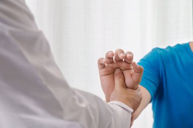 Doktor terapist hastanın eline masaj yapıyor. Hastanede ya da klinikte parmak ağrısı. 