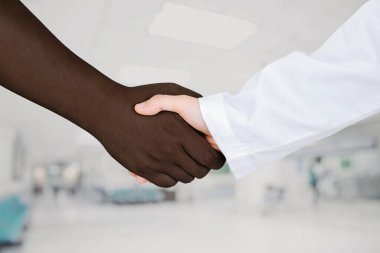 Doktorun elleri cesaretlendirmek ve empati kurmak için hastanın elini tutuyor. Ortaklık, güven ve tıbbi etik kavramı. Siyahların hayatları önemlidir. 