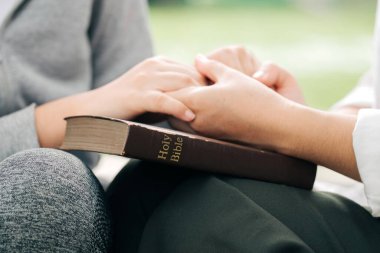 Kutsal İncil 'in üzerinde el ele tutuşan iki kadın....