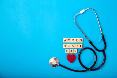 Top view world heart day stetescope with world heart day text on blue paper background. Ücretsiz kopya alanı