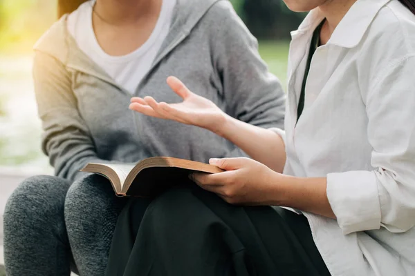 İki kadın ders çalışıyor ve İncil hakkında konuşuyor. .