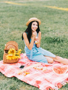Güzel kadın piknikte meyve suyu içiyor