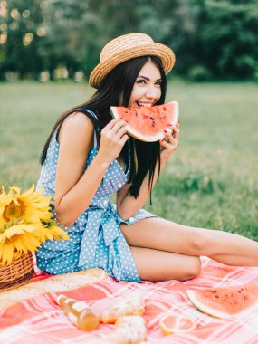 Güzel kadın piknik poz ve karpuz yeme. 