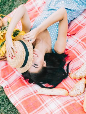 Genç bir kadın yazın piknikte yatıyor.