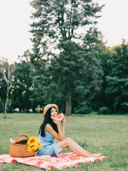 Güzel kadın piknik poz ve karpuz yeme. 