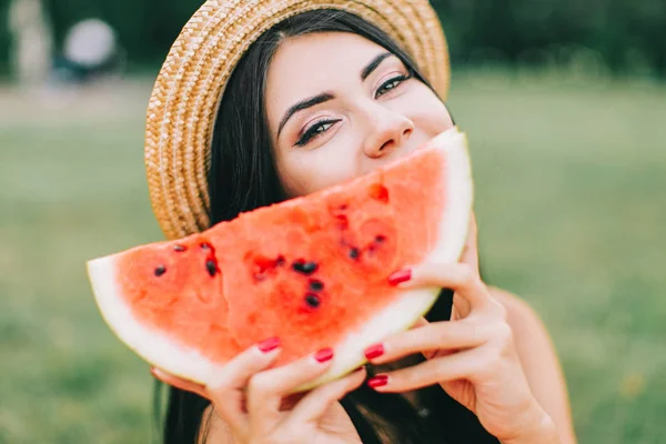 Güzel kadın piknik poz ve karpuz yeme. 