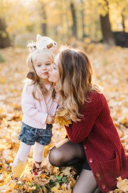 Güzel kızı ile Genç Anne altın sonbaharda parkta yürüyüş. Gül bakalım, bir selfie almak iyi eğlenceler.