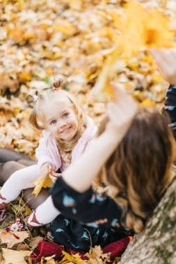 Güzel kızı ile Genç Anne altın sonbaharda parkta yürüyüş. Gül bakalım, bir selfie almak iyi eğlenceler.