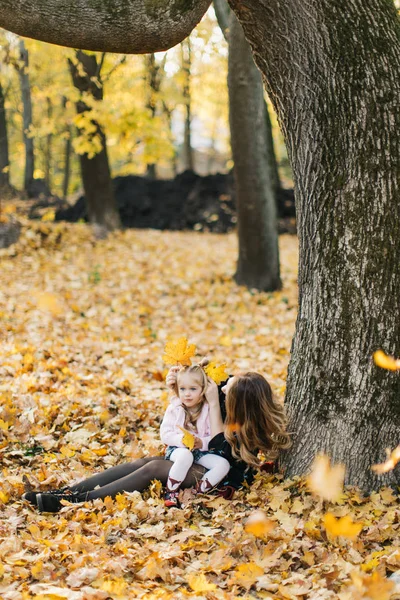 Güzel kızı ile Genç Anne altın sonbaharda parkta yürüyüş. Gül bakalım, bir selfie almak iyi eğlenceler.