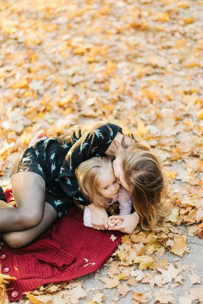 年轻的母亲与美丽的女儿正在公园散步在金色的秋天 玩得开心 拍自拍 — 图库照片