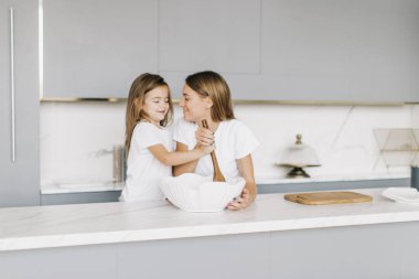 Anne ve kızı mutfakta yemek pişiriyor.