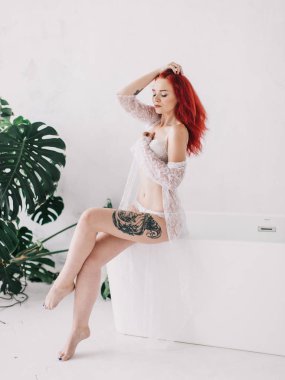 Banyo, mavi su ve çiçek alarak bir güzel kızıl saçlı kız portresi