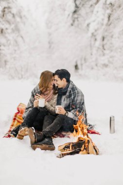 Orman Yangın ve içecek kakao tarafından ısıtılır kışın bir tarihte genç çift