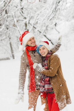 aşık ouple karlı bir ormanda yürür, gülmek ve keyfini çıkarın