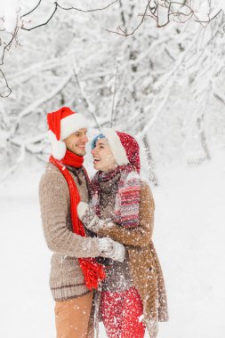 aşık ouple karlı bir ormanda yürür, gülmek ve keyfini çıkarın