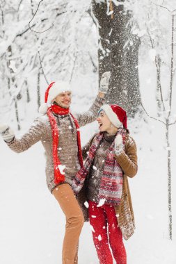 aşık ouple karlı bir ormanda yürür, gülmek ve keyfini çıkarın