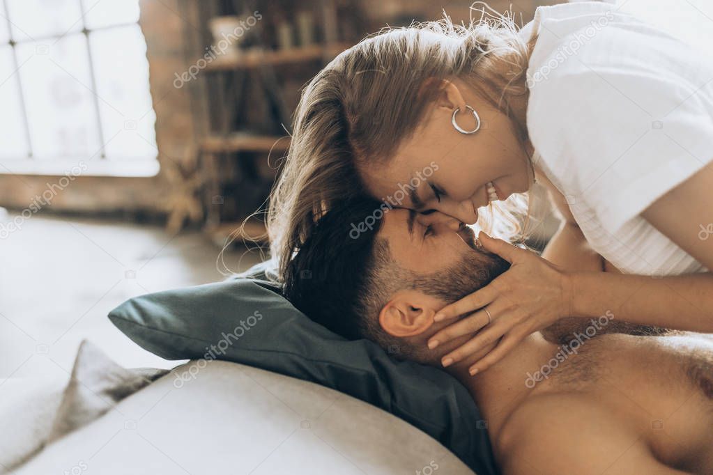 Beautiful loving couple kissing in bed