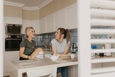 İki arkadaş mutfak, kahkaha ve konuşma, çay iç. Otantik duygu