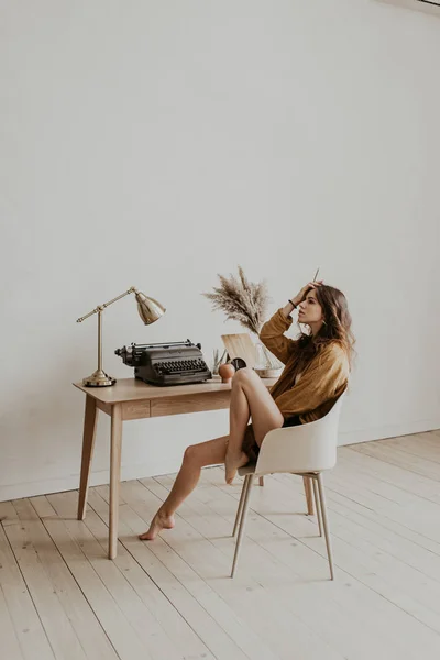 Portrait of a beautiful girl writer in the workplace