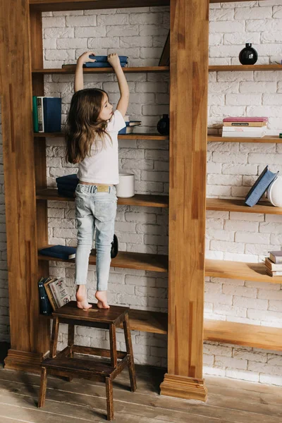 Kislány Elérte Egy Könyvet Könyvtárban — Stock Fotó