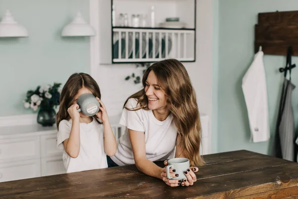 Junge Mutter Mit Schöner Tochter Trinkt Tee Der Küche — Stockfoto