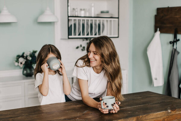 Young Mother Beautiful Daughter Drinks Tea Kitchen Royalty Free Stock Photos