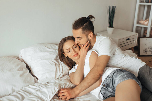 красивая любящая пара целуется в постели