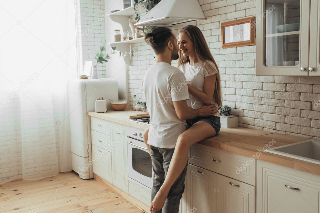 Beautiful loving couple kissing in kitchen